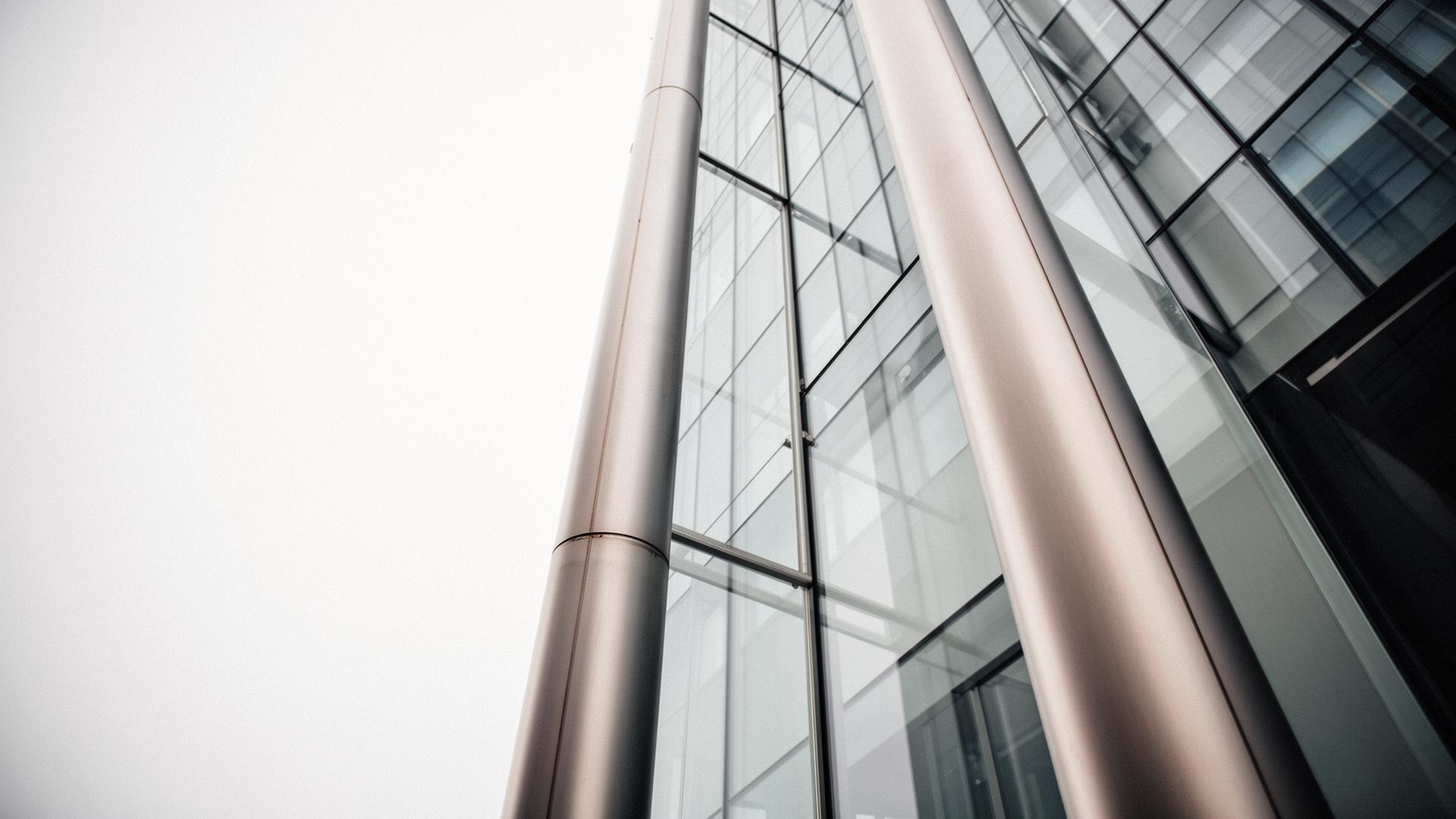 Commercial real estate structural columns viewed from below — illustrating the physical assets capital expenditure decisions are made against